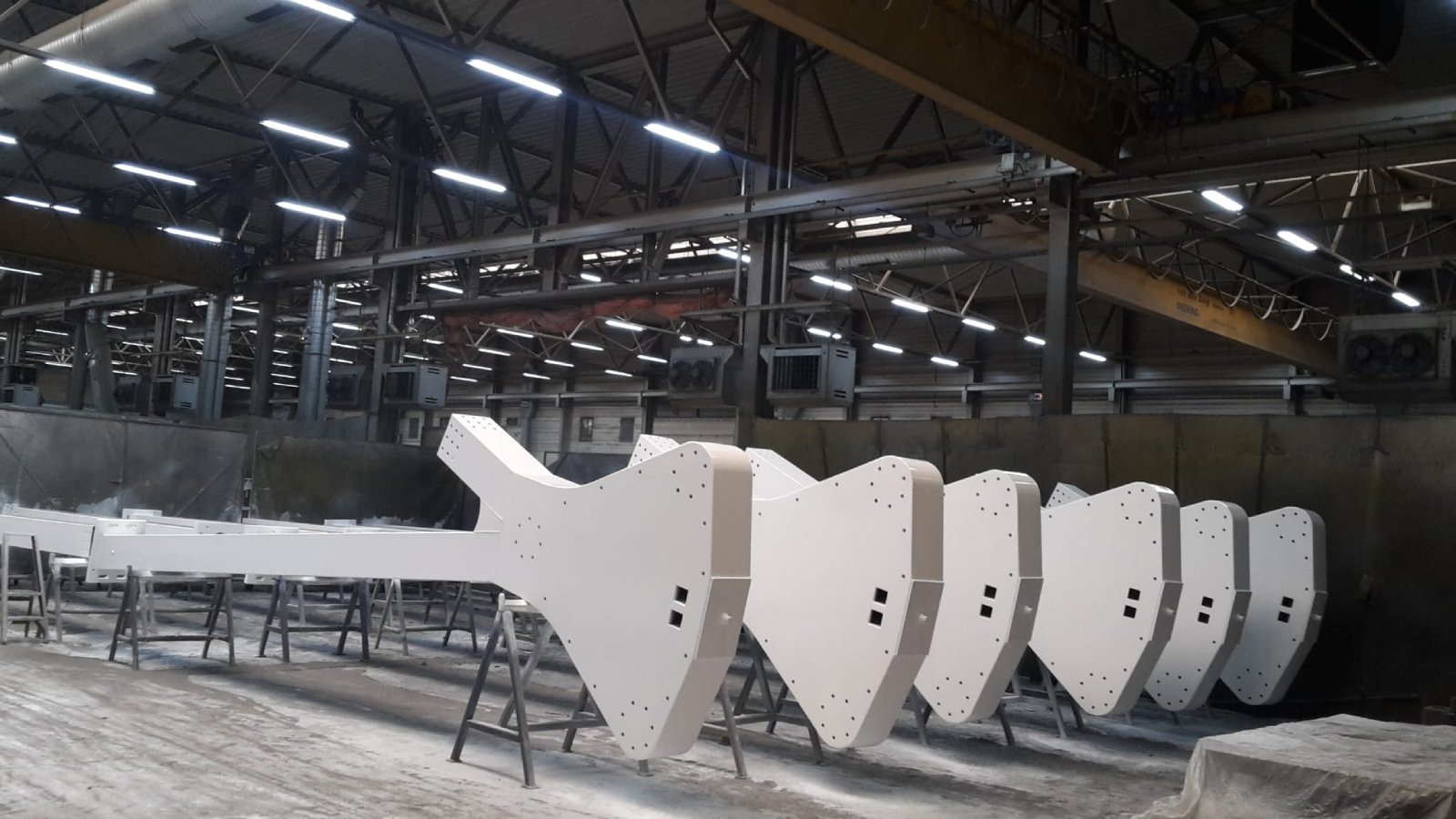 Industrial metal components sandblasted and painted white, prepared in workshop
