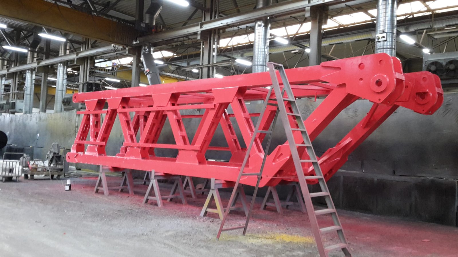 Large red structural steel beam after sandblasting and protective coating